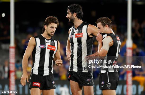 Josh Daicos, Brodie Grundy and Callum L. Brown of the Magpies look dejected after a loss during the 2022 AFL Round 04 match between the Collingwood...