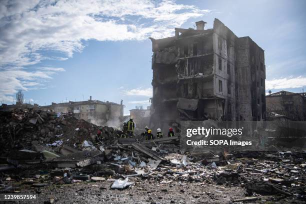 Workers clear debris from a building that collapsed due to a shelling attack in Borodyanka, a town in Kyiv Oblast, from which occupying Russian...
