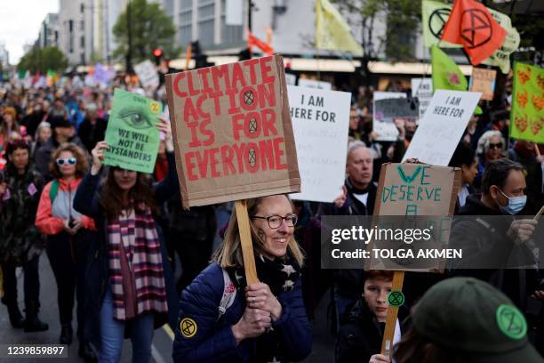 Activists march along Oxford Street during a demonstration by the climate change protest group Extinction Rebellion in London on April 9 during a...