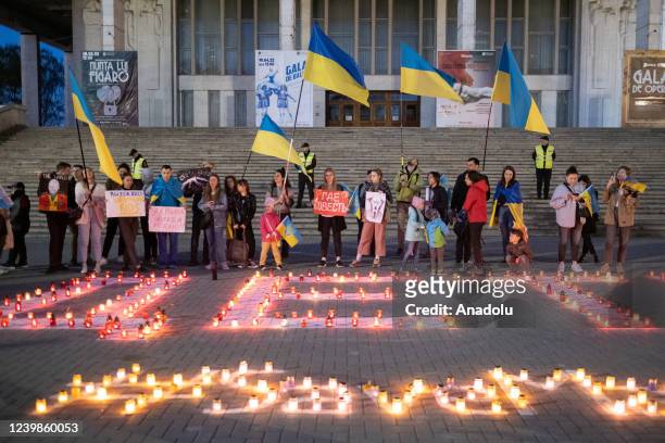 Candles are lit to pray for the people who lost their lives in Mariupol during protest against Russian attacks on Ukraine in front of the National...