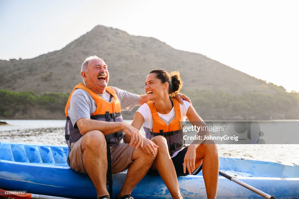 Hombre y mujer españoles disfrutando de kayak temprano por la mañana