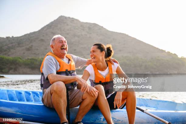 spanish male and female enjoying early morning kayaking - senior adult stock pictures, royalty-free photos & images