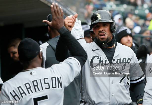 Jose Abreu of the Chicago White Sox celebrates with Josh Harrison after scoring against the Detroit Tigers on a hit by Eloy Jimenez during the first...