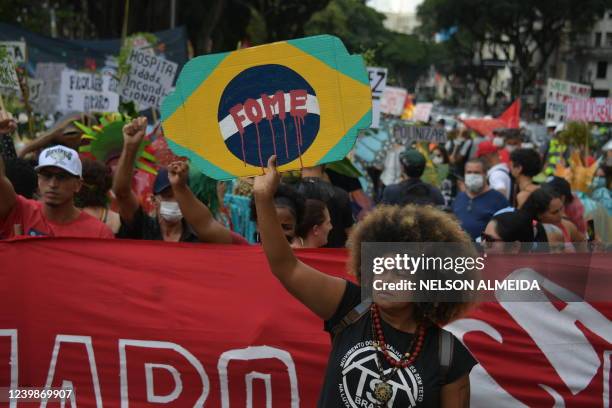 Demonstrator holds a placard reading "Hunger" as members of opposition parties and social movements protest against Brazilian President Jair...