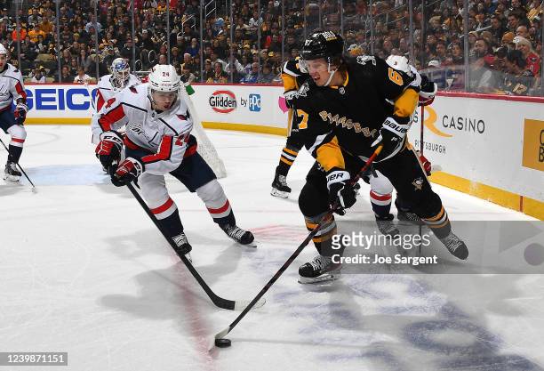 Rickard Rakell of the Pittsburgh Penguins controls the puck against Connor McMichael of the Washington Capitals in the first period during the game...