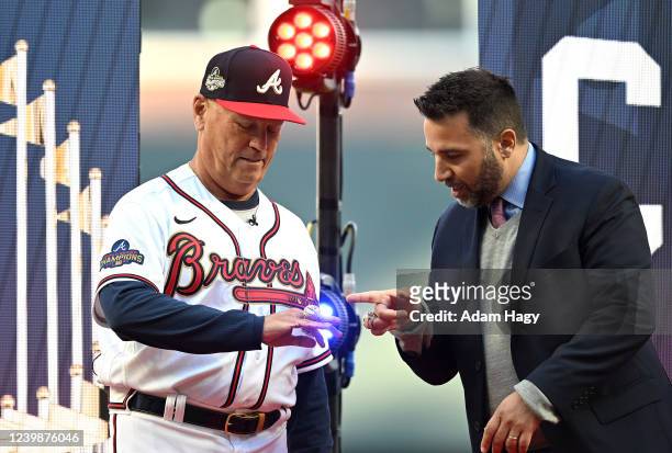 Brian Snitker and Alex Anthopoulos of the Atlanta Braves looks at the World Series ring during the World Series Ring Ceremony before the game against...