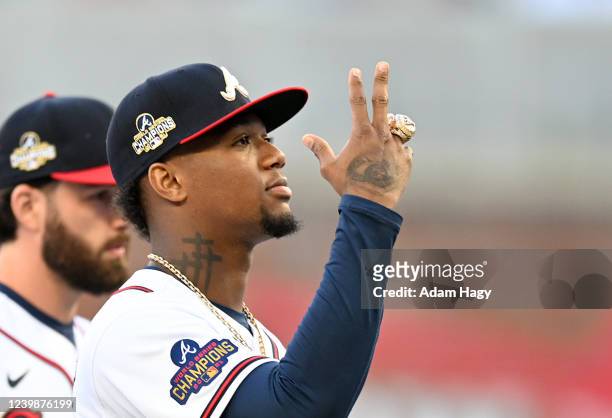 Ronald Acuna Jr of the Atlanta Braves gestures with his World Series ring during the ring ceremony before the game against the Cincinnati Reds at...