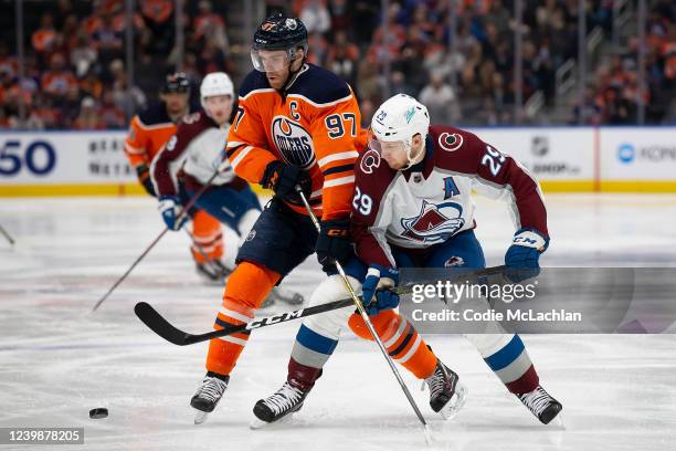 Connor McDavid of the Edmonton Oilers battles against Nathan MacKinnon of the Colorado Avalanche during the second period at Rogers Place on April 9,...