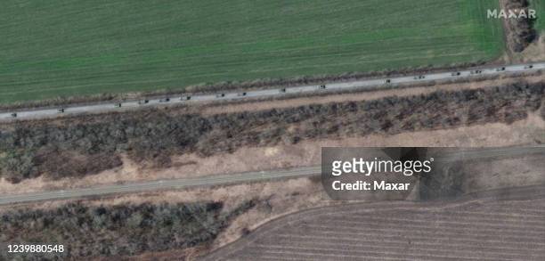 Maxar satellite imagery of trucks with towed artillery on the southern end of an 8 mile long Russian military convoy moving through Velykyi Burluk,...