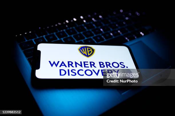 Warner Bros. Discovery logo displayed on a phone screen and a laptop keyboard are seen in this illustration photo taken in Krakow, Poland on April 9,...