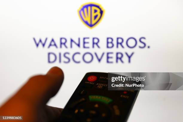 Warner Bros. Discovery logo displayed on a screen and a tv remote control are seen in this illustration photo taken in Krakow, Poland on April 9,...