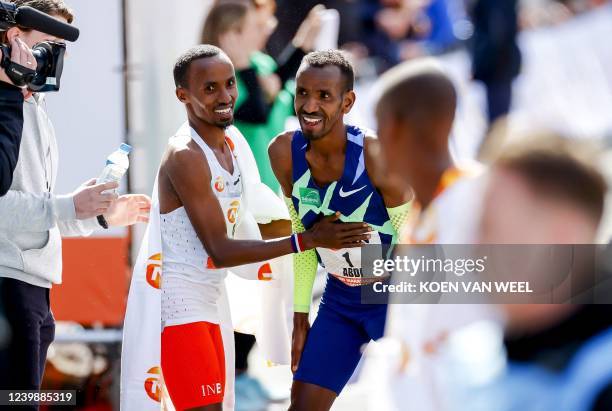 Belgian Bashir Abdi and Dutch winner Abdi Nageeye react at the end of the 41st edition of the Rotterdam Marathon in Rotterdam, on April 10, 2022. - -...