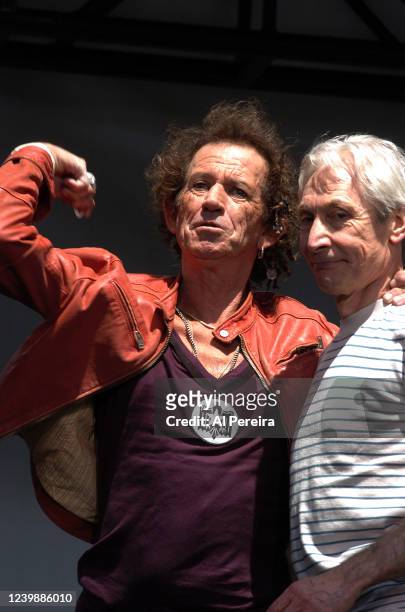 Keith Richards tosses out guitar picks and while Charlie Watts watches when they and The Rolling Stones perform during a press conference to announce...