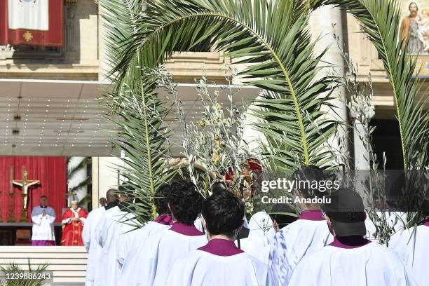 Altar boys hold palm branches as Pope Francis, seen in background, attends the Palm Sunday Mass in St. Peter's square at the Vatican City Vatican, on...