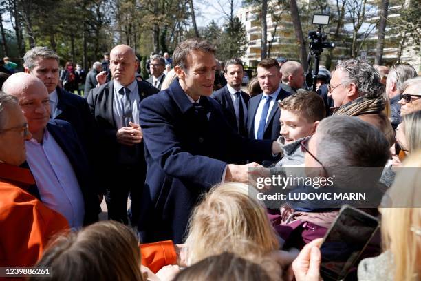 France's President and LREM party presidential candidate Emmanuel Macron greets onlookers following the casting of his ballot for the first round of...