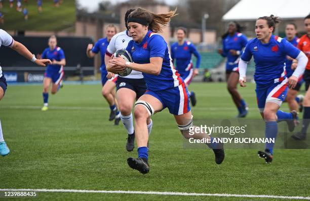 France's flanker Gaelle Hermet runs to score the team's fourth try during the Six Nations international women's rugby union match between Scotland...