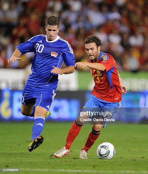 Juan Mata of Spain beats Sandro Wieser of Liechtenstein during the EURO 2012 Qualifier match between Spain and Liechtenstein at estadio Las Gaunas on...