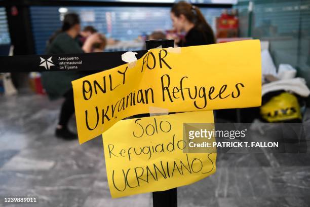 Signs indicate an area designated for Ukrainian refugees upon arrival at the Tijuana airport, where they are met by volunteers to assist them in...