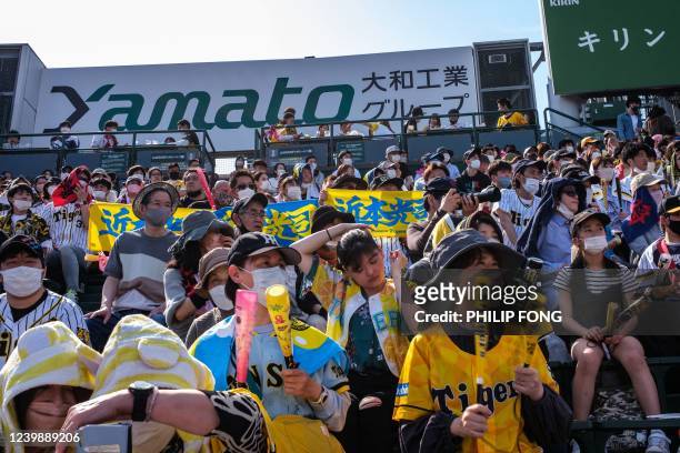 Fans watch a match between Hanshin Tigers and Hiroshima Toyo Carp at Koshien Stadium in Nishinomiya, Hyogo prefecture, on April 10, 2022.