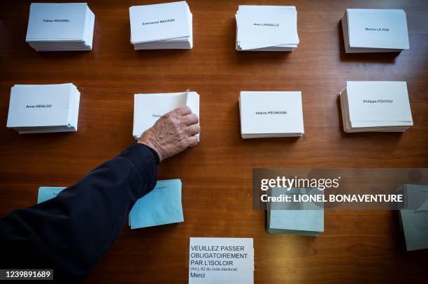 Voter takes ballots before voting for the first round of France's presidential election at a polling station in Toulouse, southwestern France on...