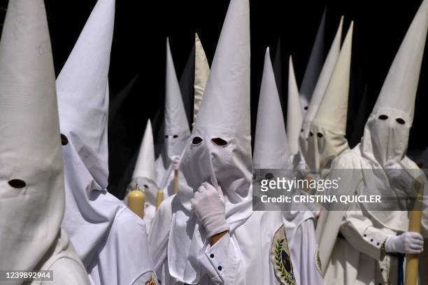 Penitents of 'La Paz' brotherhood parade during the Holy Week's Palm Sunday procession in Seville on April 10, 2022. - Christian believers around the...