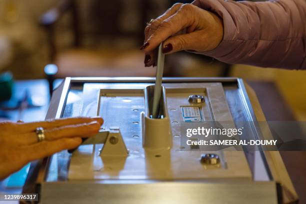 Woman casts her vote for the first round of France's presidential election at a polling station in the Mont Saint-Michel on April 10, 2022.