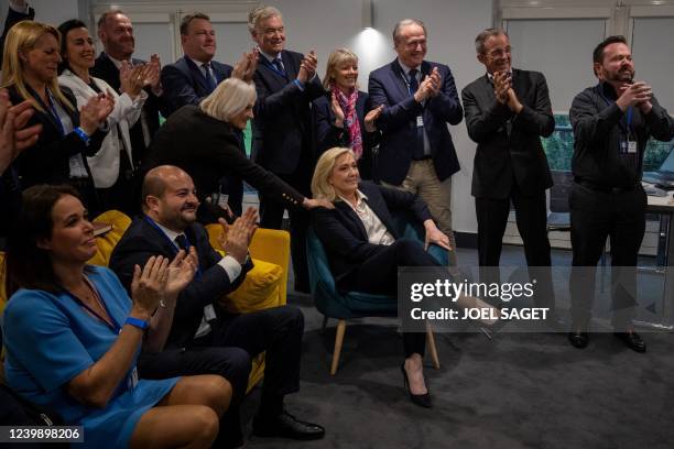 French far-right party Rassemblement National's presidential candidate Marine Le Pen is congratulated by her sister Marie-Caroline next to RN party...