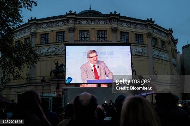Supporters of French presidential candidate Jean-Luc Melenchon watch him speaking on a screen outside an election night event for Melenchon,...