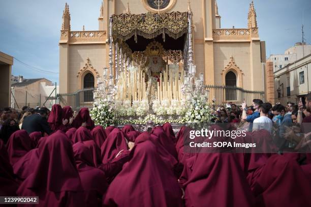 Penitents of âSaludâ brotherhood are seen praying in front of an ornate float with the statue of the Virgin Mary as they take part in a...