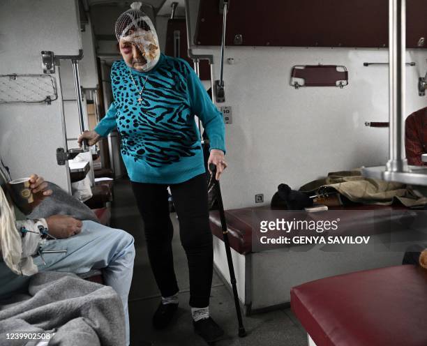 Praskovya is walking in a carriage of a medical evacuation train on its way to the the western Ukrainian city of Lviv on April 10, 2022. - Doctors...