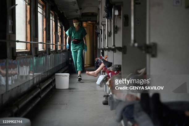 Elena an MSF team member, cares for patients on a medical evacuation train on its way to the western Ukrainian city of Lviv on April 10, 2022. -...