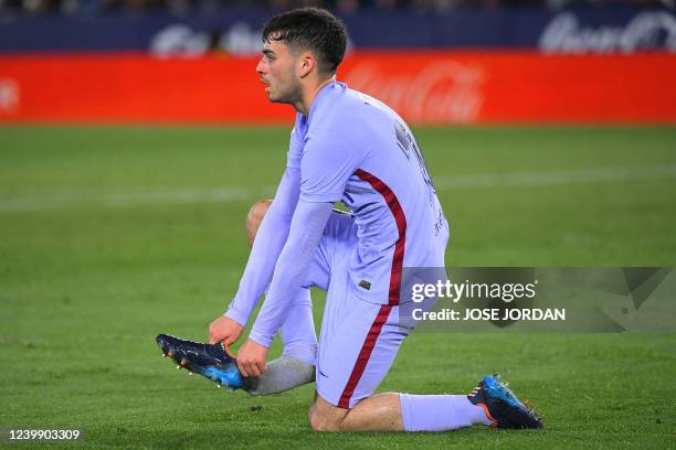 Barcelona's Spanish midfielder Pedri puts on his shoe during the Spanish league football match between Levante UD and FC Barcelona at the Ciutat de...