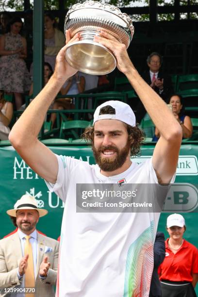 Reilly Opelka hoists the trophy for winning the US Clay Court Championships singles finals match between Reilly Opelka and John Isner at River Oaks...