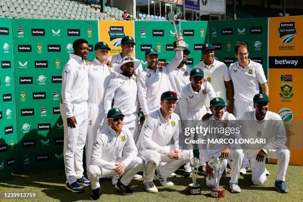 South Africa's Dean Elgar holds the trophy as the South African team poses for a photo after winning the series following the second Test cricket...