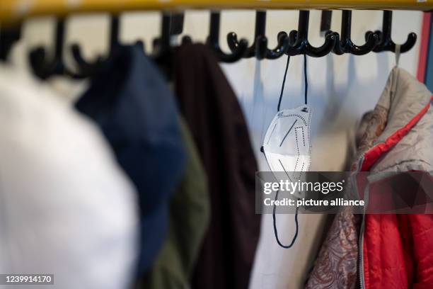 April 2022, Baden-Wuerttemberg, Stuttgart: An FFP2 mask, hangs on coat hooks outside a preparatory class 4 classroom at the Ameisenberg School. In...