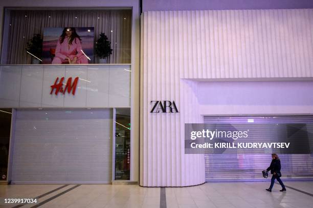 Woman walks past the closed H&M and Zara shops at a shopping mall in Moscow on April 11, 2022. - On February 24 Russia started military action in...