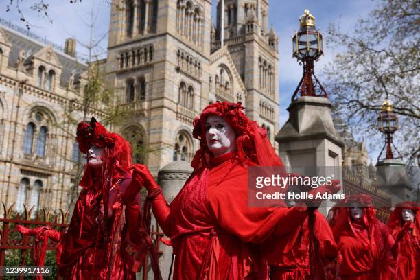 Members of the Red Rebel Brigade perform outside the Natural History Museum during an Extinction Rebellion protest on April 11, 2022 in London,...