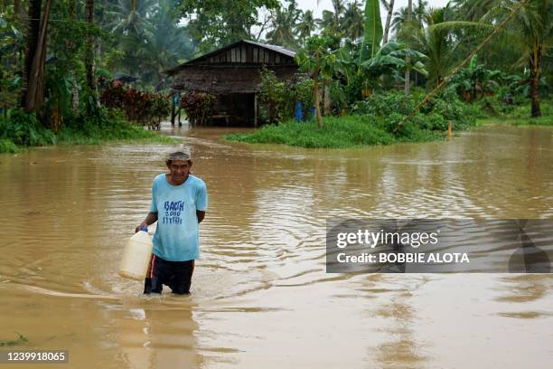 Resident wades through a flooded pathway next to his house in Abuyog town, Leyte province, southern Philippines, on April 11 following heavy rains...