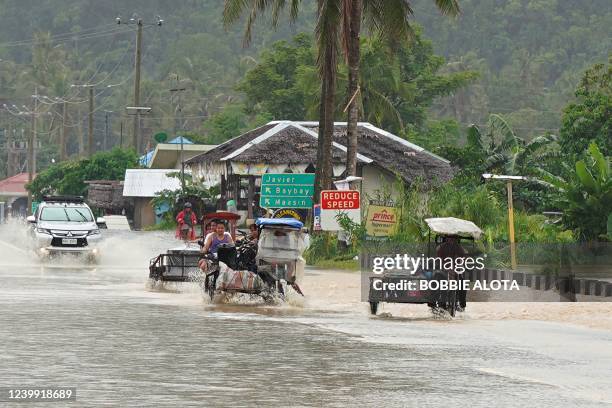 Motorists wade through a flooded road after heavy rains brought about by Tropical storm Agaton in Abuyog town, Leyte province, southern Philippines...