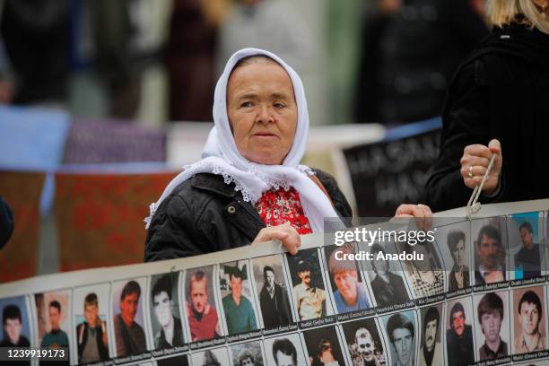 Women from Srebrenica attend a peaceful demonstration in front of the 'Heart of Jesus' Cathedral and a statue depicting Pope John Paul II, in memory...