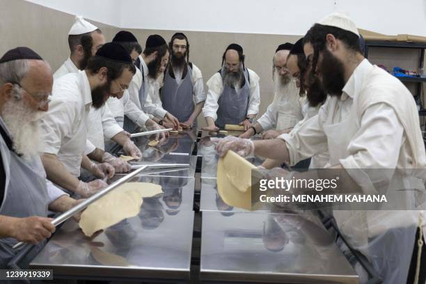Ultra-Orthodox Jewish men knead the Matzoth dough at a bakery in the central Israeli city of Beit Shemesh, on April 11, 2022. - Religious Jews...
