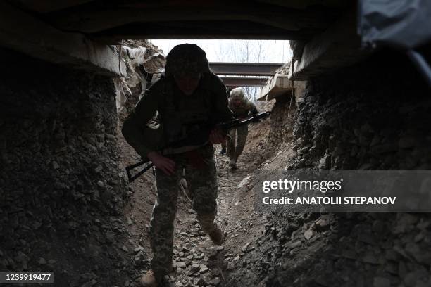 Ukrainian soldiers walk through a tunnel of a trench on the front line with Russian troops in Lugansk region on April 11, 2022.