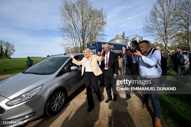 French far-right party Rassemblement National presidential candidate Marine Le Pen raises her arms for the media, followed by her personal body guard...