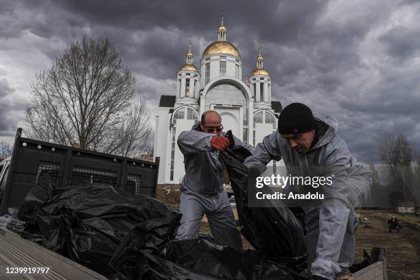 Officials exhume the bodies of civilians who died during the Russian attacks, from mass graves in Bucha, Ukraine on April 11, 2022. According to the...