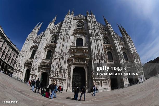 Photograph taken with a fishey lens on April 11, 2022 shows people strolling in front of the Duomo di Milano on Duomo square, in central Milan.