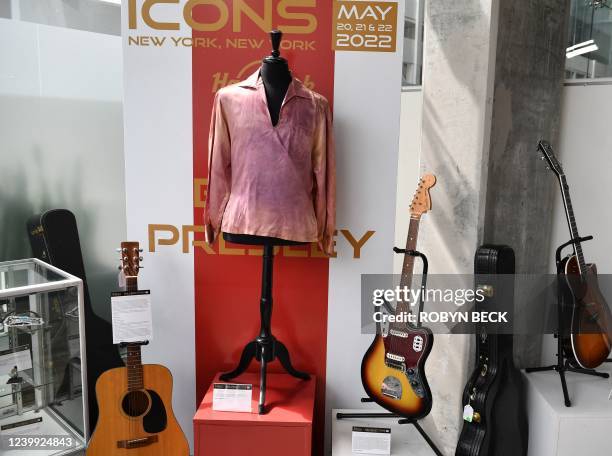 An Elvis Presley owned and worn pink flower long sleeve shirt, along with an Elvis owned and played Fender Jaguar guitar with case, strap and pick,...