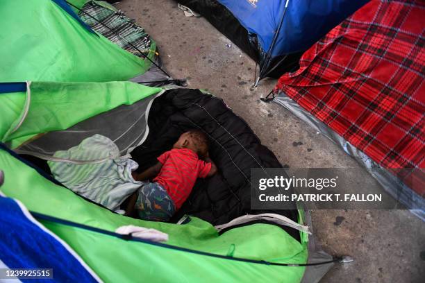 Child sleeps in a tent as they live with their family in the Movimiento Juventud 2000 shelter with refugee migrants from Central and South American...