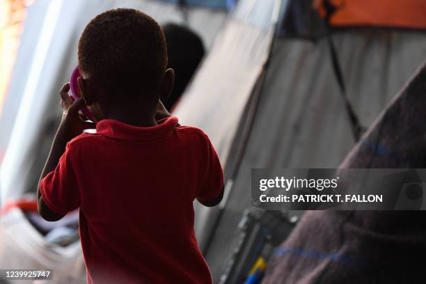 Child drinks from a bowl as they live with their family in the Movimiento Juventud 2000 shelter with refugee migrants from Central and South American...