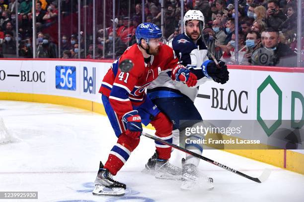 Dylan DeMelo of the Winnipeg Jets clears the puck while being challenged by Paul Byron of the Montreal Canadiens in the NHL game at the Bell Centre...