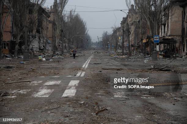 Woman walks along in a destroyed Mariupol street. The battle between Russian / Pro Russian forces and the defending Ukrainian forces led by the Azov...